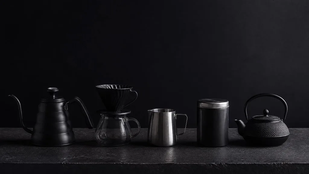 A kettle, dripper, pitcher, canister and cast iron teapot in a row